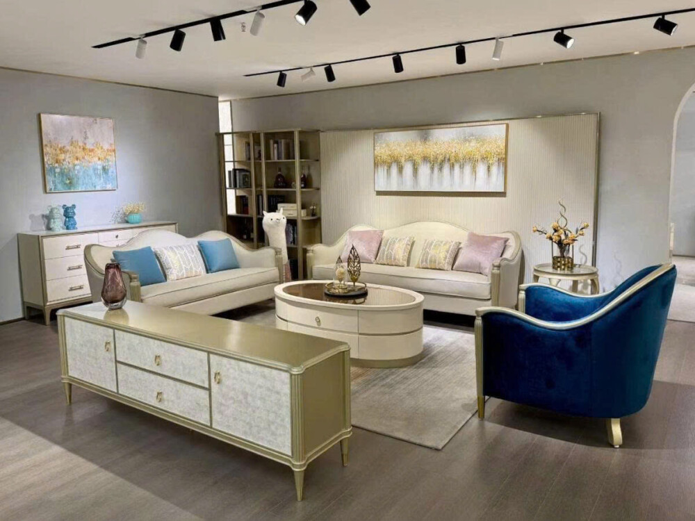 Góc rộng phòng khách trưng bày bộ sofa SF619016-123 màu kem và một ghế bành đơn màu xanh navy, cùng bàn trà hình oval và k…