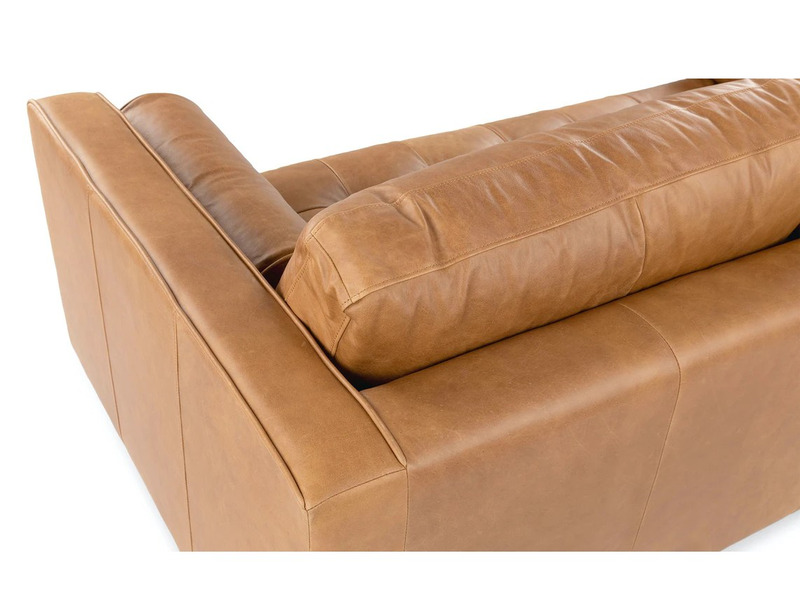 Cận cảnh góc của sofa băng SF-433 màu nâu da bò, tập trung vào đệm lưng, tay vịn và gối ôm tròn. Chất liệu da công nghiệp…