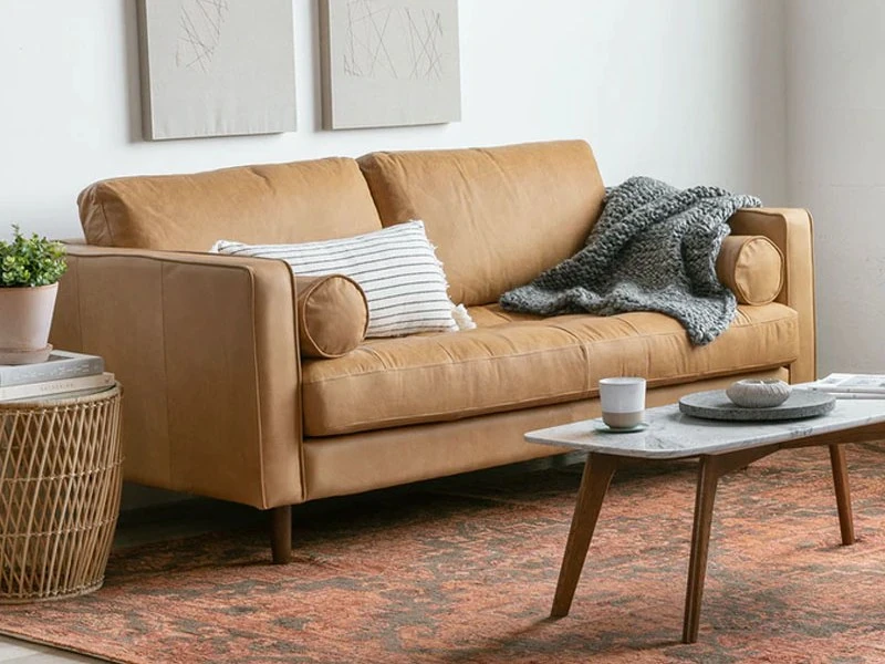 Sofa băng SF-433 bọc da công nghiệp màu nâu da bò, chụp góc nghiêng từ phải, đặt trong phòng khách hiện đại. Bối cảnh có b…