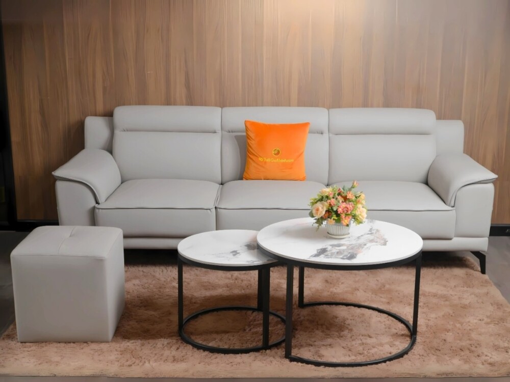 Bộ sofa băng SB01 màu xám nhạt, đi kèm đôn vuông và bàn trà đôi mặt đá, được bài trí trong không gian phòng khách hiện đại…