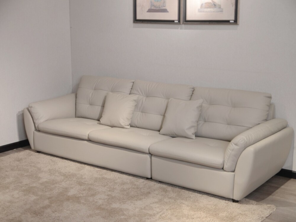 Sofa băng 2m8 SFA07-28 màu be nhạt, chụp góc thấp, đặt trên thảm lông màu be. Hình ảnh làm nổi bật phần chân sofa thấp, th…