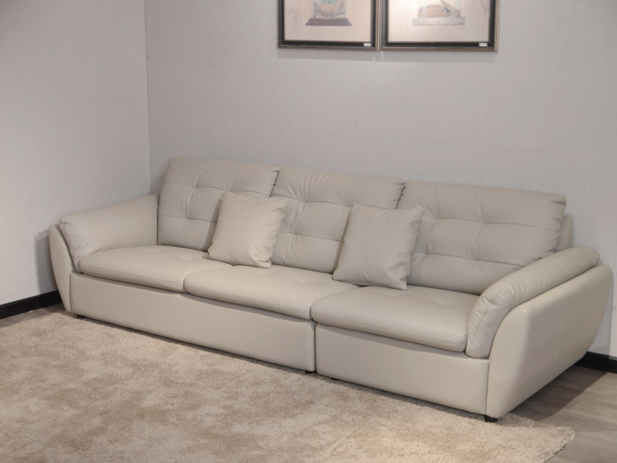 Sofa băng 2m8 SFA07-28 màu be nhạt, chụp góc thấp, đặt trên thảm lông màu be. Hình ảnh làm nổi bật phần chân sofa thấp, th…