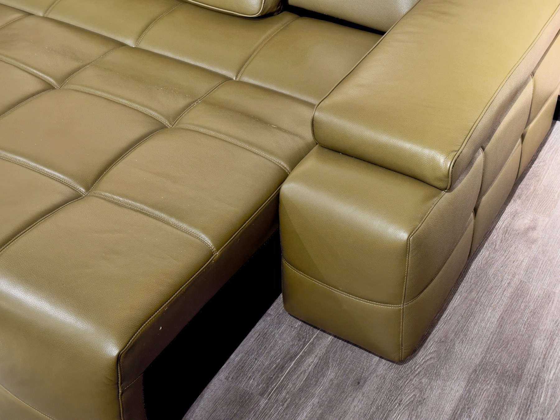 Cận cảnh góc nối giữa phần đệm ngồi và tay vịn của ghế sofa chỉnh điện SF8116 màu xanh rêu. Ảnh làm nổi bật kết cấu khối h…
