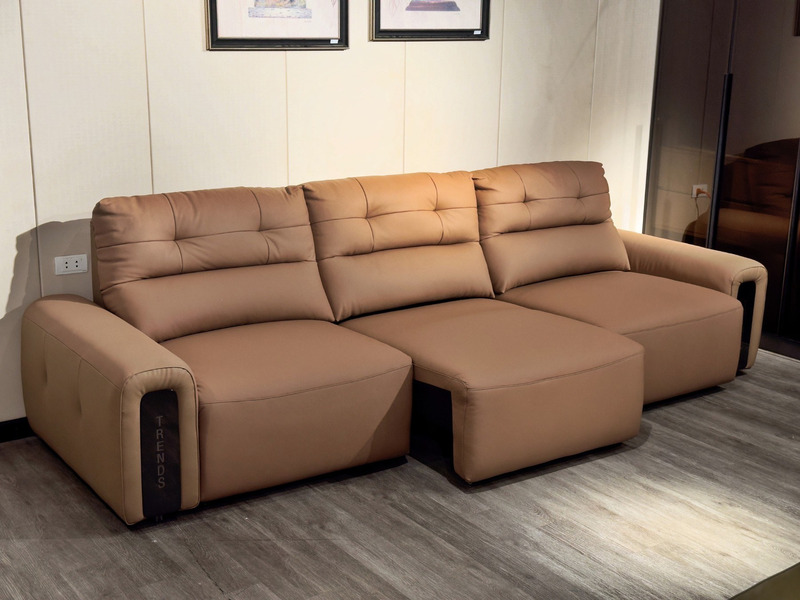 Ghế sofa chỉnh điện SF8144 màu nâu be chụp từ góc thấp, nhìn nghiêng. Sofa có cấu hình chữ L với đôn dài, bọc da bò tự nhi…