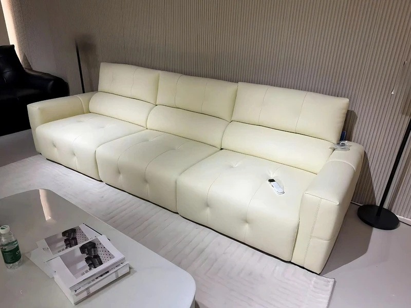 Ghế sofa chỉnh điện SF8138 màu kem nhạt, bọc da bò tự nhiên, đặt trong không gian phòng khách hiện đại. Sofa có thiết kế d…