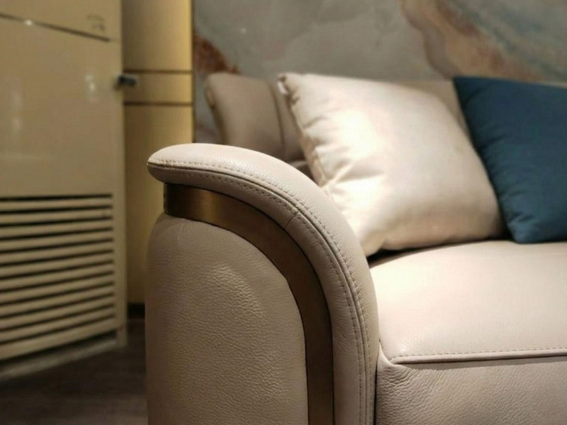Cận cảnh tay vịn của sofa SBQ929-4, cho thấy chất liệu da bò tự nhiên màu be nhạt với đường may tinh tế. Phần tay vịn được…