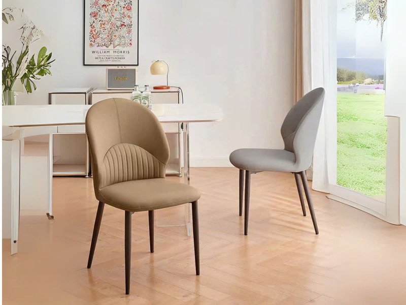 Hai chiếc ghế ăn phong cách hiện đại được chụp từ góc chính diện, đặt cạnh bàn ăn màu trắng trong không gian phòng ăn sáng…