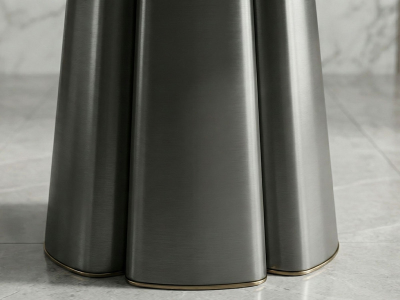 Cận cảnh phần chân bàn ăn tròn BA841-135, làm từ inox màu xám đậm với thiết kế hình cánh hoa độc đáo. Các cạnh chân bàn đư…