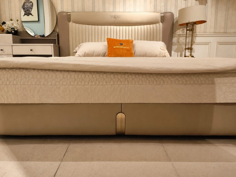 Cận cảnh phần thành giường và chân giường thấp của Giường ngủ WINGA Luxury GIQF285-18, bọc da màu trà sữa, chân giường kim…
