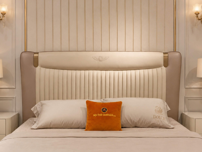 Cận cảnh đầu giường Giường ngủ WINGA Luxury GIQF285-18 trong phòng ngủ, nổi bật logo cánh chim thêu trên nền da bò màu trà…