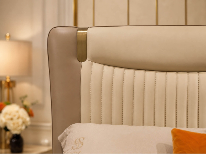 Chi tiết phần bo cong của đầu giường Giường ngủ WINGA Luxury GIQF285-18, bọc da màu trà sữa, kết hợp dải kim loại mạ vàng…