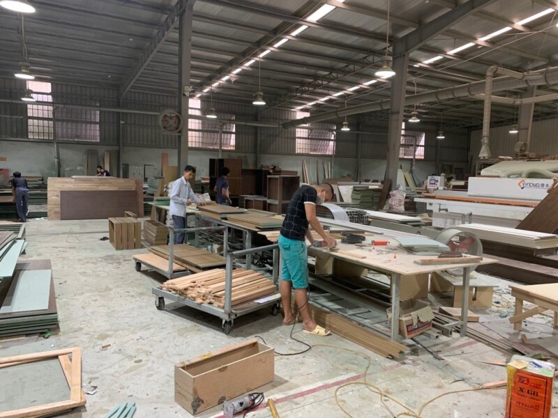 Thợ gia công chi tiết gỗ trên bàn máy tại xưởng Gia Khánh