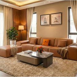 Sofa băng SFA38-32 ba chỗ ngồi và đôn đi kèm, bọc da bò màu nâu caramel, được đặt trong không gian phòng khách hiện đại. G…