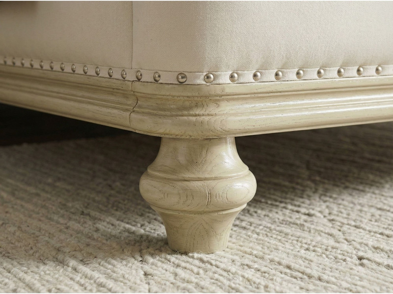 Chi tiết chân giường GI2803-18 hình trụ tròn tiện hoa văn, sơn màu vàng nhạt, đặt trên thảm lông màu trắng. Phần viền khun…