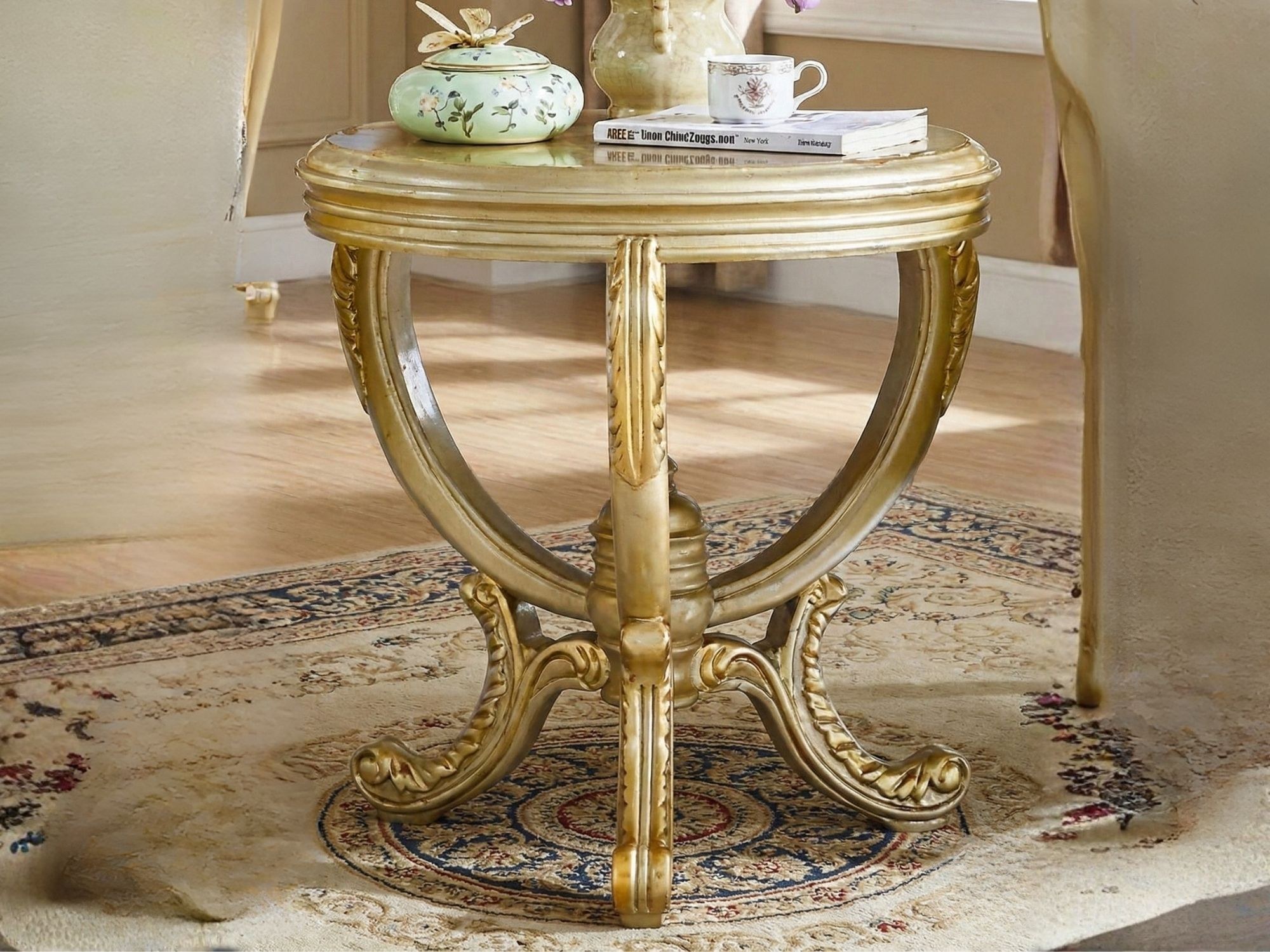 Cận cảnh bàn tròn thư giãn GT01-NT đặt trên thảm trải sàn họa tiết cổ điển. Bàn có mặt gỗ tròn màu vàng kem, chân uốn cong…