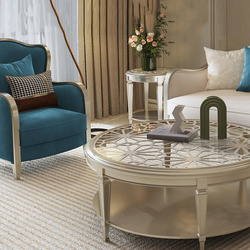 Ghế sofa đơn bọc vải màu xanh ngọc với khung gỗ sơn bạc, đặt cạnh bàn trà tròn mặt kính cường lực có họa tiết trang trí ti…