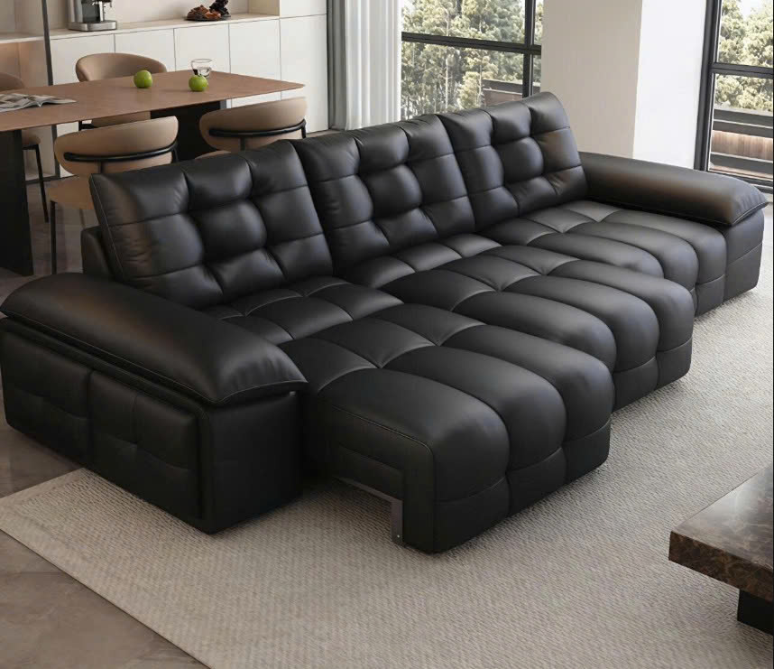 Ghế sofa chỉnh điện SF201 màu đen, chụp từ góc nhìn rộng hơn, làm nổi bật thiết kế chữ L và phần tựa lưng cao. Sofa được b…
