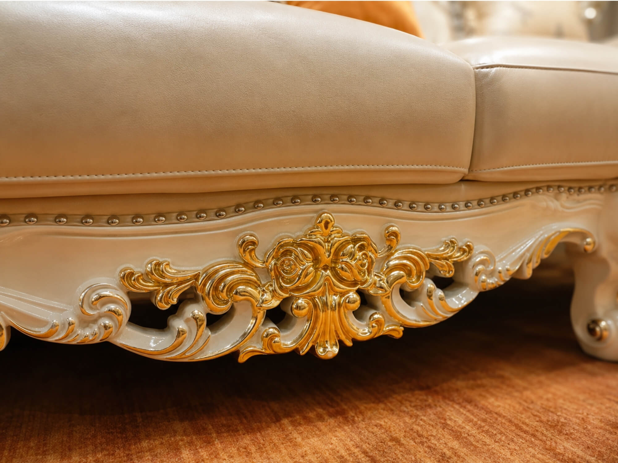 Cận cảnh phần đế của ghế sofa băng 3, với đường viền được trang trí bằng các đinh tán kim loại nhỏ. Các họa tiết chạm khắc…