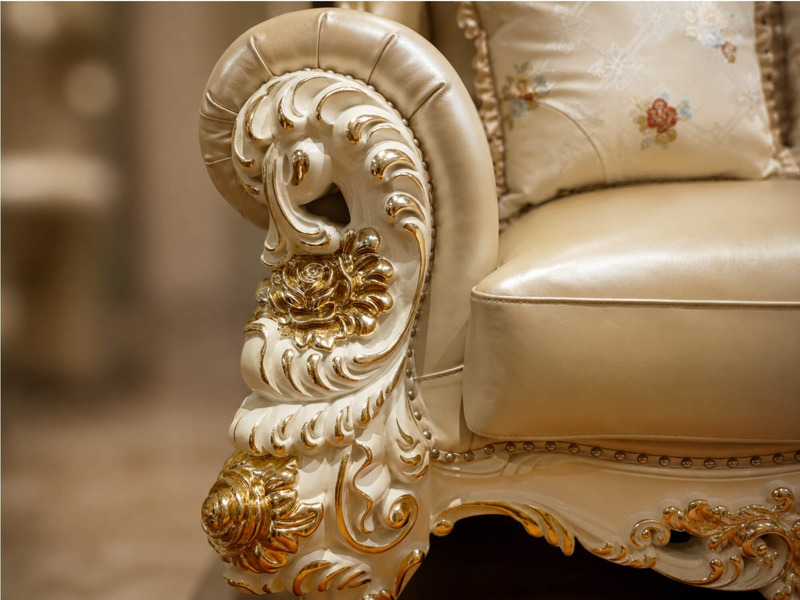 Cận cảnh tay vịn của ghế sofa băng 1, với các đường nét chạm khắc hoa văn mạ vàng tinh xảo trên nền gỗ Sồi tự nhiên màu k…