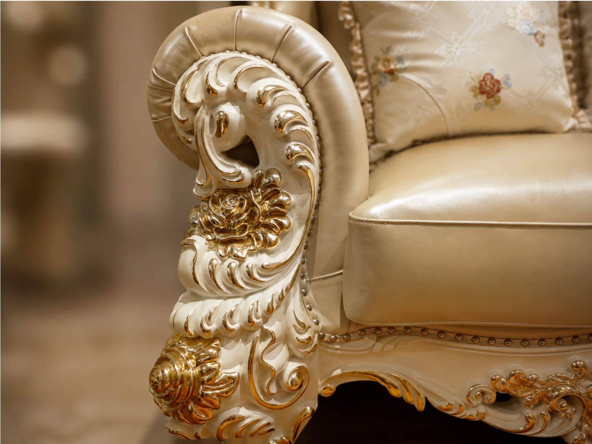 Cận cảnh tay vịn của ghế sofa băng 1, với các đường nét chạm khắc hoa văn dát vàng tinh xảo trên nền gỗ Sồi tự nhiên màu k…