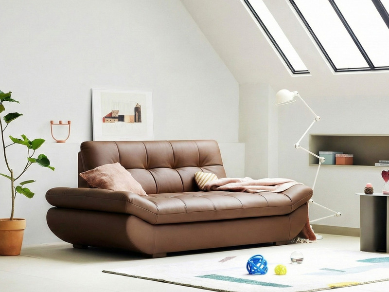 Sofa PUFFY màu nâu, góc chụp hơi nghiêng từ phía trước bên trái, làm nổi bật thiết kế dáng thuyền hiện đại. Tựa lưng và đệ…