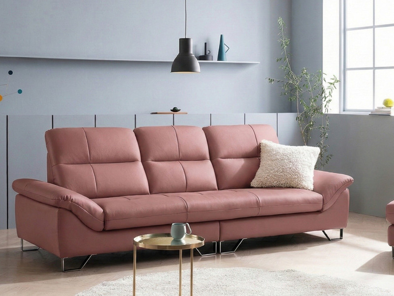 Sofa băng EMBRACE màu hồng indie, chụp từ góc chính diện hơi chếch, đặt trong phòng khách hiện đại với tường xám và sàn gỗ…