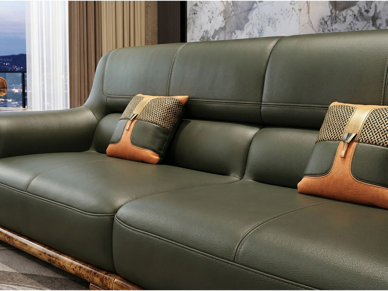 Cận cảnh phần lưng tựa và đệm ngồi của sofa băng dài, cho thấy chất liệu da bò tự nhiên màu xanh rêu đậm với các đường may…