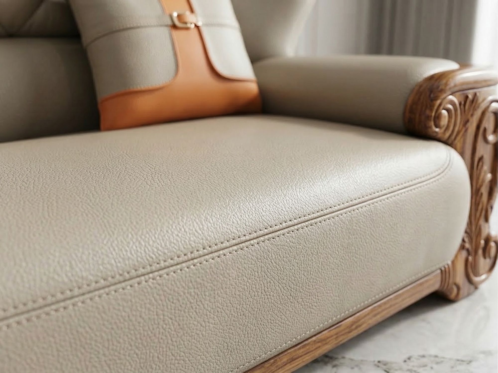 Chi tiết đường may đôi tinh xảo trên bề mặt đệm ngồi và tay vịn của sofa, bọc da bò màu kem. Phần khung gỗ mun tự nhiên lộ…