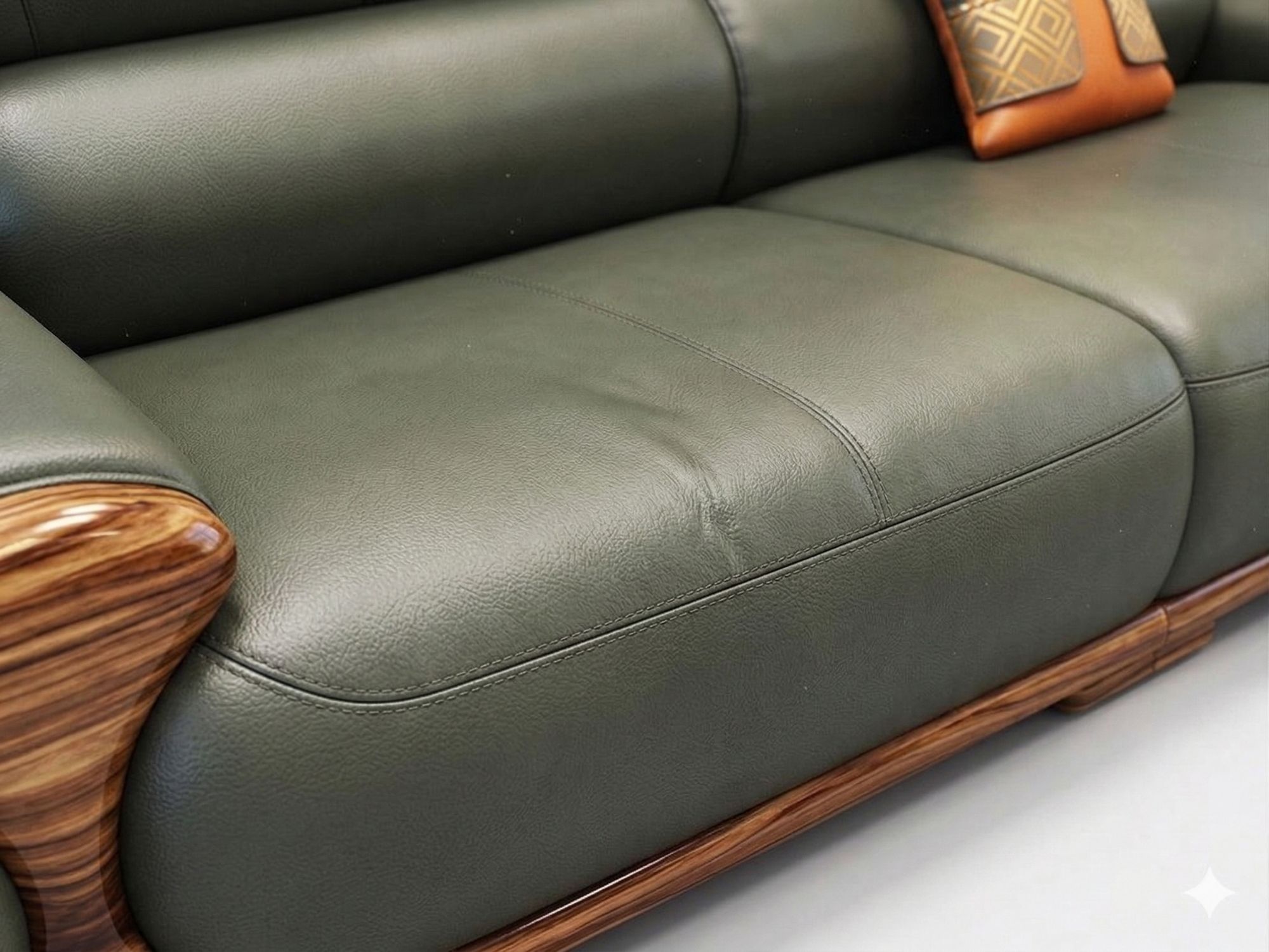 Chi tiết bề mặt đệm ngồi và tay vịn của sofa, với chất liệu da bò tự nhiên màu xanh rêu mềm mại, đường may tinh xảo. Phần…