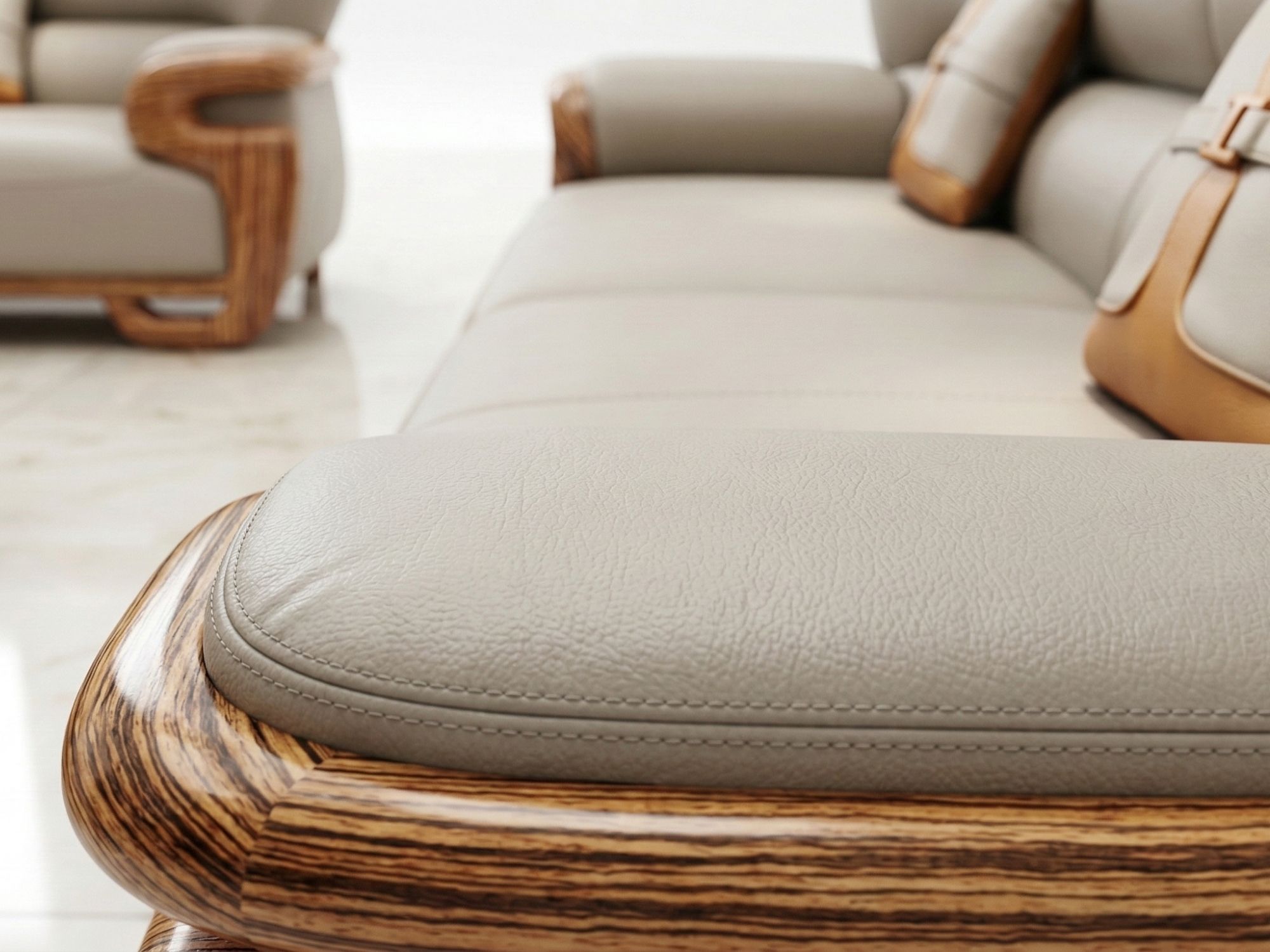 Cận cảnh bề mặt đệm ngồi và phần tay vịn của ghế sofa, cho thấy chất liệu da bò màu kem với đường may tinh xảo. Khung gỗ m…