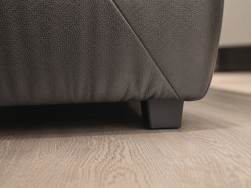 Chi tiết chân ghế sofa băng SF-HY07-30 màu đen, hình hộp chữ nhật thấp, đặt trên sàn gỗ màu sáng. Chân ghế được thiết kế c…