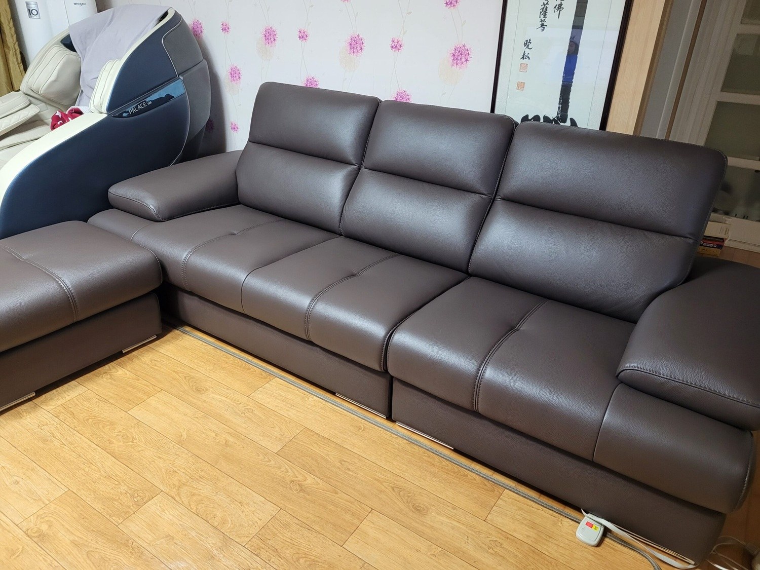 Hình ảnh thực tế sofa LULLABY màu nâu sẫm, chụp cận cảnh từ góc thấp, làm nổi bật chất liệu da cao cấp và các đường may ké…