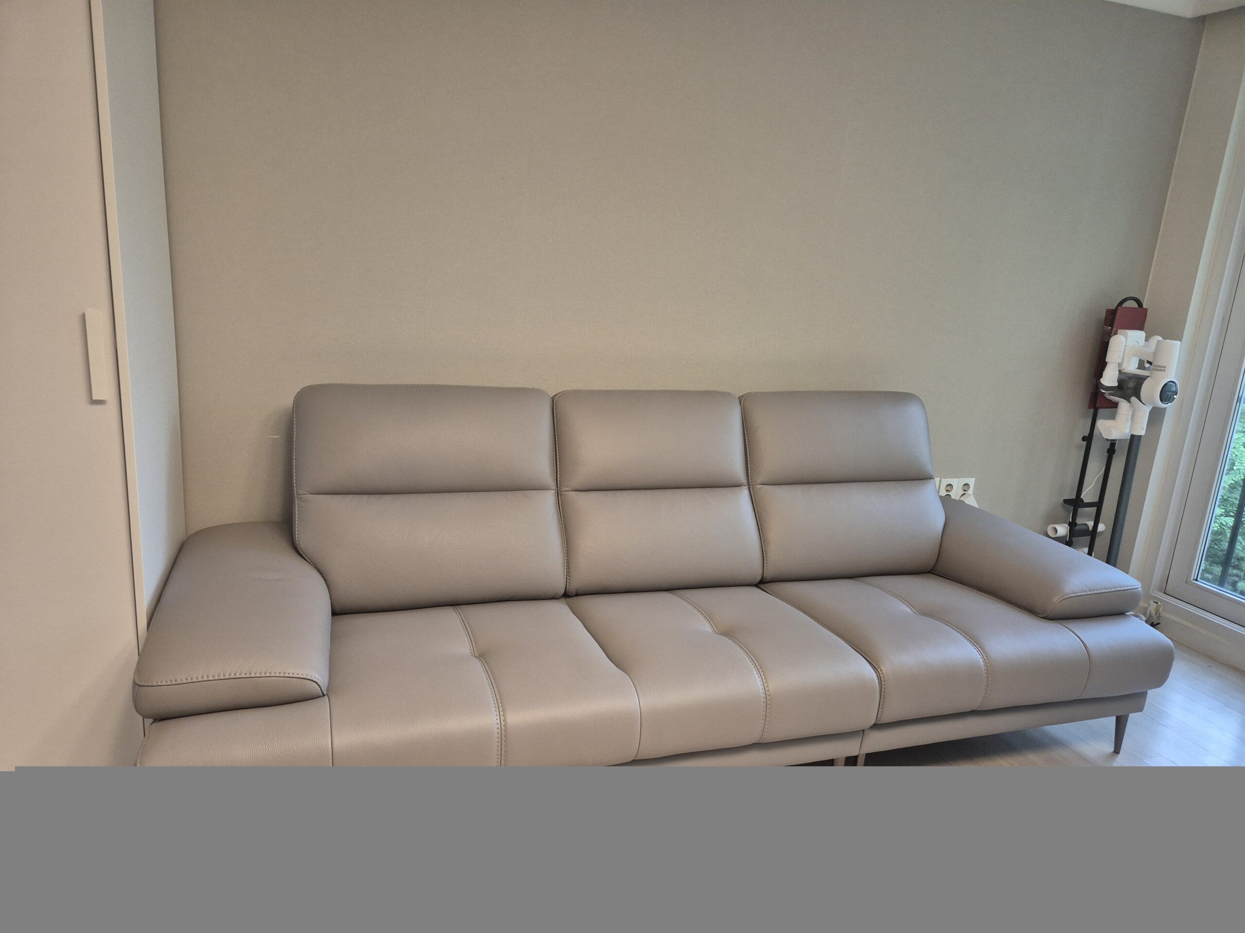 Sofa LULLABY dạng băng màu kem nhạt, chụp ngang tầm mắt, thể hiện rõ chiều dài và độ sâu của ghế. Thiết kế hiện đại với ta…