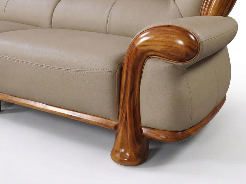 Cận cảnh tay vịn ghế sofa bọc da màu be, nổi bật với phần khung gỗ Mun tự nhiên được chạm khắc uốn lượn mềm mại, vân gỗ đẹ…