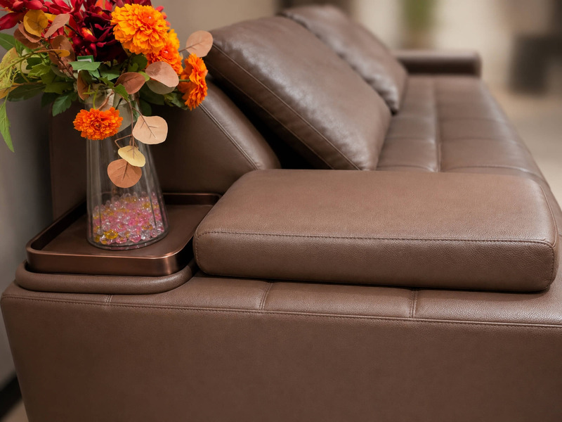 Cận cảnh tay vịn của ghế sofa chỉnh điện SF8132, bọc da bò màu nâu, tích hợp khay gỗ nhỏ tiện lợi để đặt đồ uống hoặc vật…