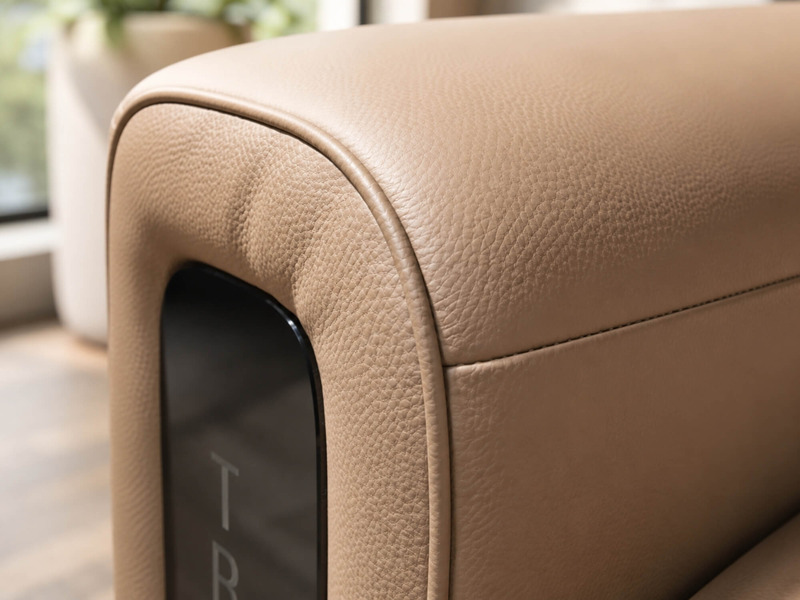Cận cảnh góc bo tròn mềm mại của tay vịn ghế sofa chỉnh điện SF8144 màu nâu be, kết hợp với chi tiết màu đen bóng ở cạnh…