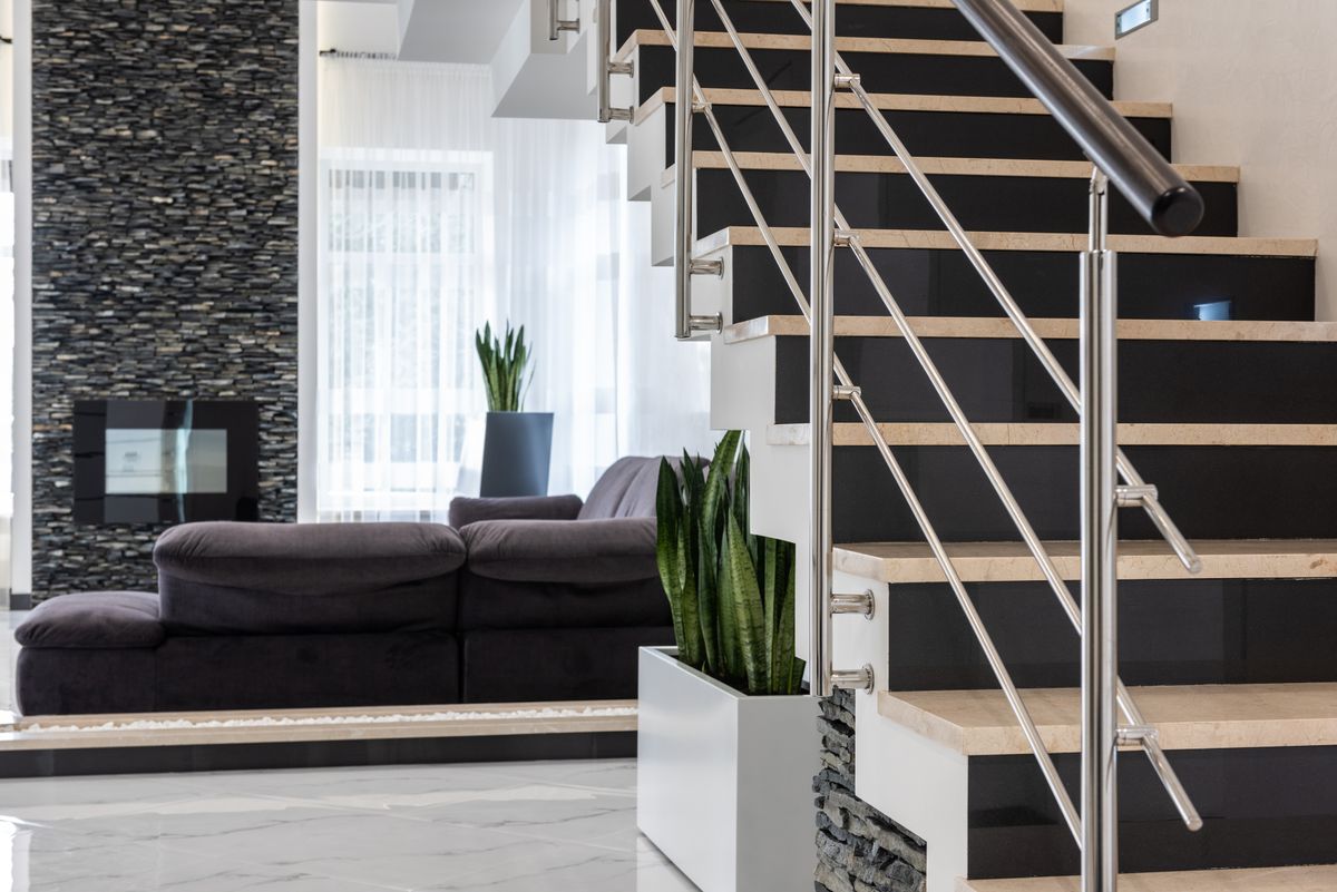 Phòng khách rộng trong biệt thự có cầu thang, sofa và cây xanh