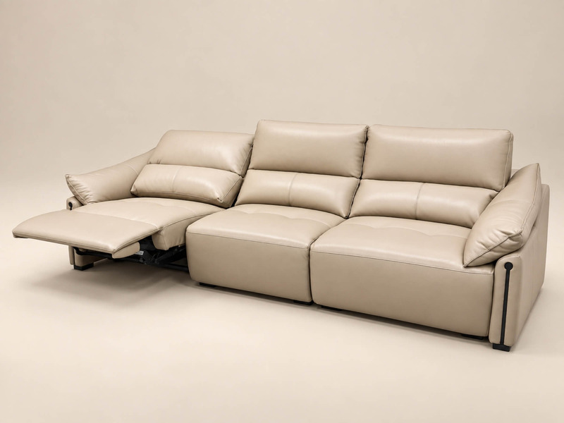 Ghế sofa băng ba COCOON màu be nhạt, được chụp từ góc hơi nghiêng, thể hiện tính năng chỉnh điện. Một phần ghế đã được ngả…