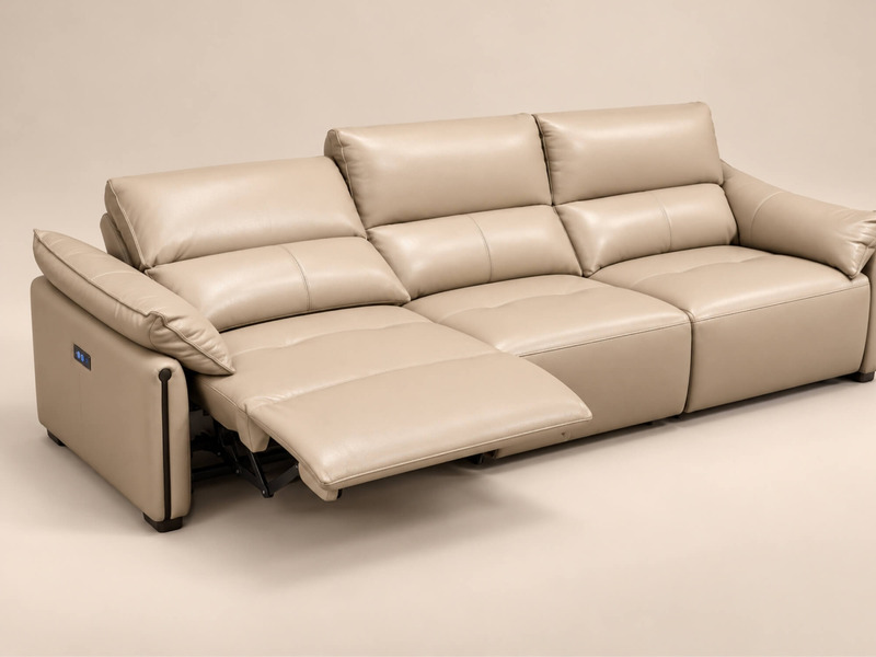 Ghế sofa băng ba COCOON màu be nhạt, chụp từ góc nghiêng, làm nổi bật tính năng chỉnh điện. Ghế đã ngả ra với phần đỡ chân…
