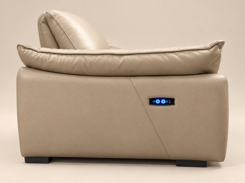 Cận cảnh chi tiết tay vịn bo tròn của ghế sofa COCOON màu be nhạt. Nút điều khiển chỉnh điện màu xanh dương phát sáng được…