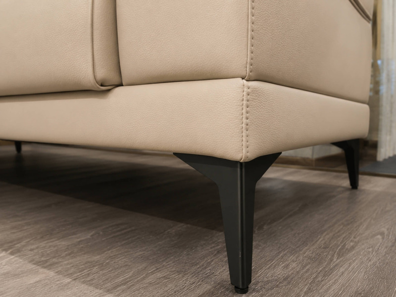 Góc chụp cận cảnh chân sofa Belluno SB01 bằng kim loại màu đen, kết hợp với phần thân ghế bọc da màu kem, tạo sự tương phả…