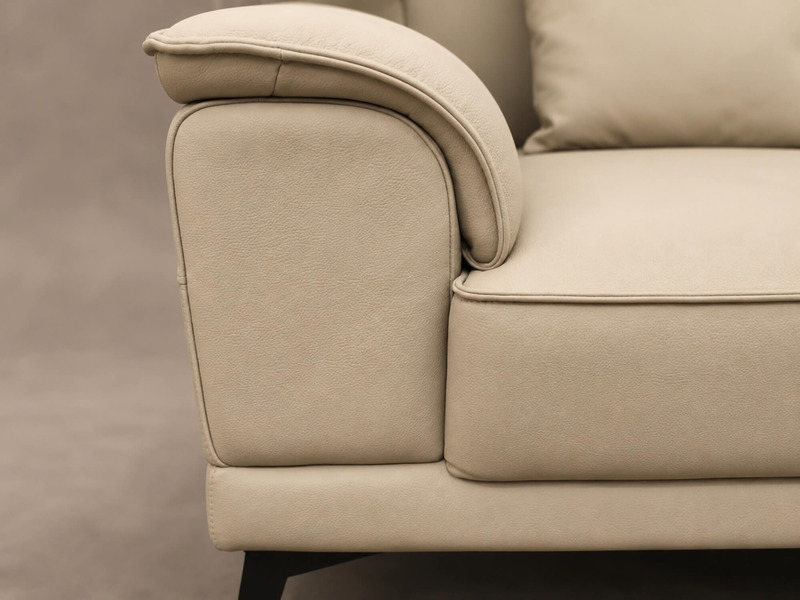 Cận cảnh phần tay vịn và tựa lưng của sofa Belluno SB01, với đường cong mềm mại, bọc da màu kem, mang lại cảm giác thoải m…