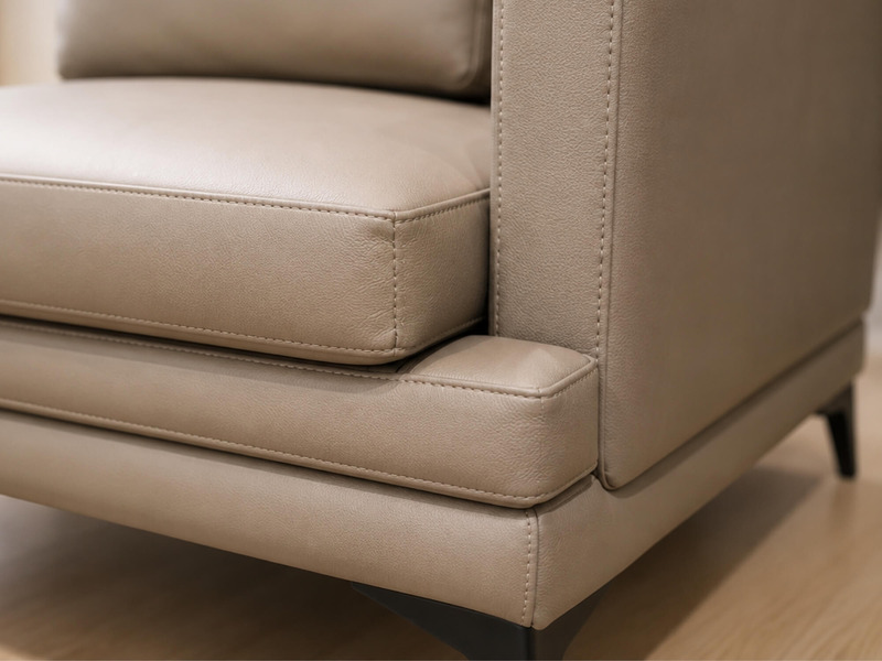 Góc chụp thấp tập trung vào chân ghế kim loại màu đen và phần đáy của sofa LEXINGTON màu nâu be, cho thấy sự vững chãi và…