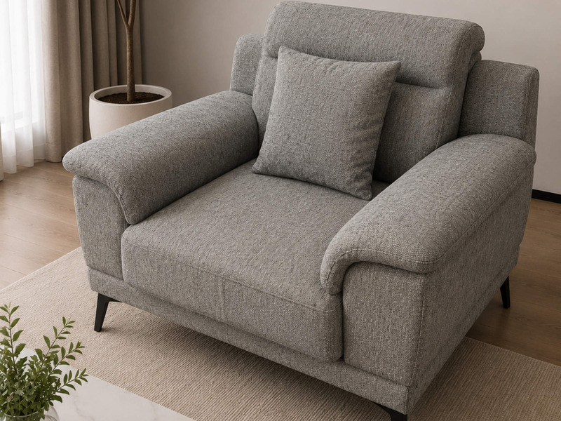 Góc chụp nghiêng cận cảnh sofa đơn Belluno SB01 màu xám nhạt. Ghế có tựa lưng cao, đệm ngồi êm ái và tay vịn bo cong mềm m…