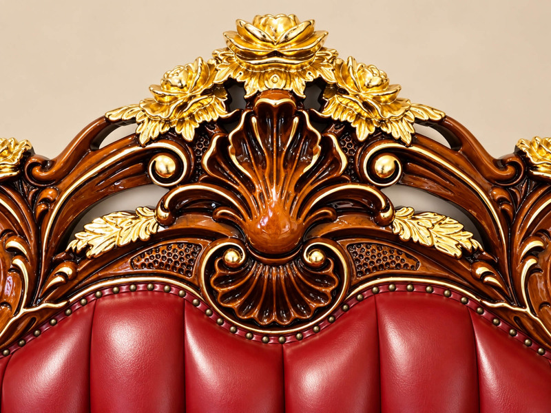 Chi tiết đỉnh lưng tựa sofa CRIMSON EMPEROR, tập trung vào hoa văn lá mạ vàng trên nền gỗ gõ đỏ tự nhiên. Các đường n…