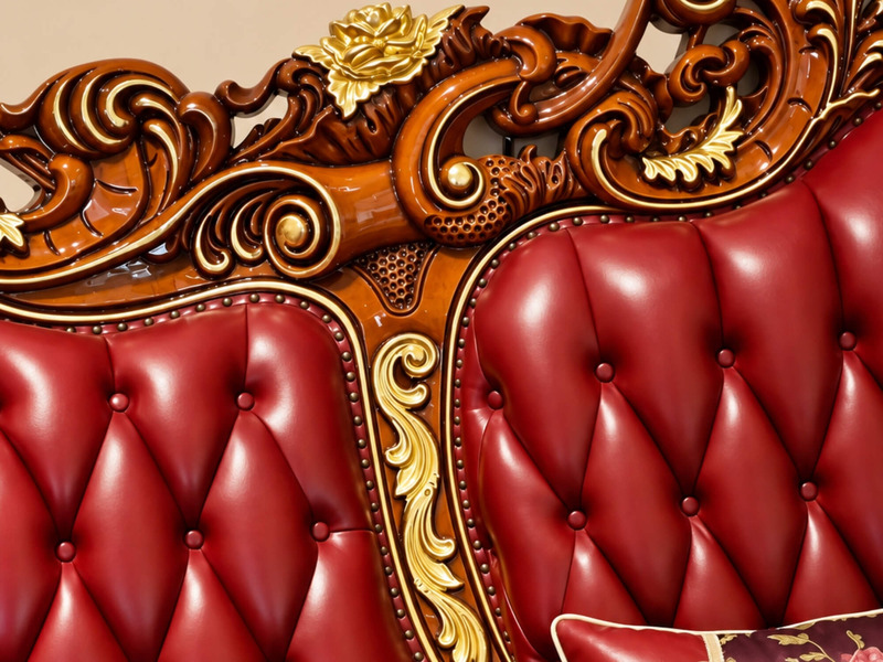 Góc cận chi tiết đường cong của tay vịn và lưng tựa sofa CRIMSON EMPEROR. Phần da bò màu đỏ đô được rút múi đều đặn, kết h…