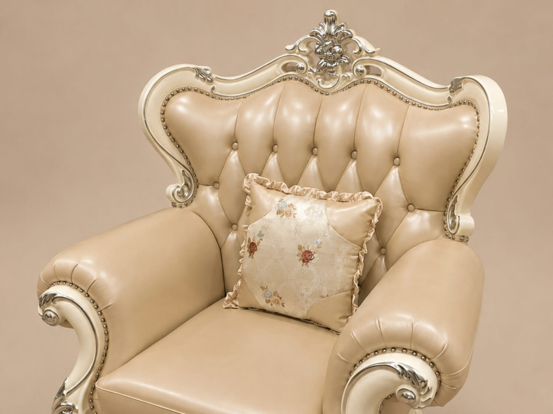 Góc nhìn cận cảnh phần lưng và tay vịn của ghế sofa đơn VALERION, bọc da bò màu kem với tựa lưng rút múi (capitone) tinh t…