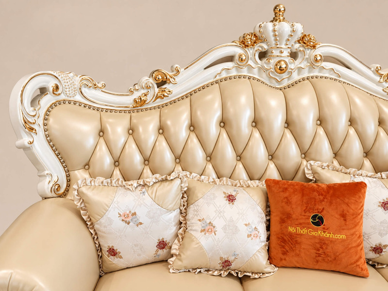 Cận cảnh lưng tựa và gối tựa của sofa băng VERSALÉON, với các đường rút múi đều đặn trên bề mặt da kem. Gối trang trí họa…