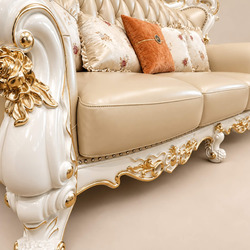 Cận cảnh tay vịn và phần chân ghế sofa VERSALÉON, cho thấy chi tiết chạm khắc tinh xảo trên khung gỗ màu kem. Các họa tiết…