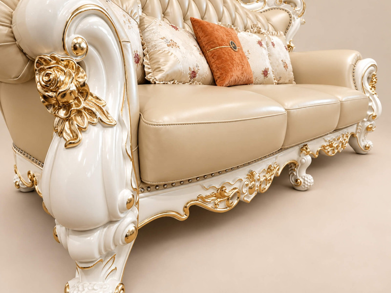Cận cảnh tay vịn và phần chân ghế sofa VERSALÉON, cho thấy chi tiết chạm khắc tinh xảo trên khung gỗ màu kem. Các họa tiết…